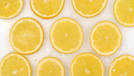 Super-Slow-Motion-Shot-of-Splashing-Water-to-many-orange-Slices-view-from-above